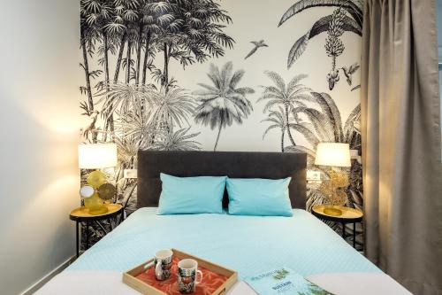 马略卡岛帕尔马Bonita Casa Sa Font en Santa Catalina, Palma Centro的一间卧室配有一张带蓝色枕头的床和棕榈树壁纸