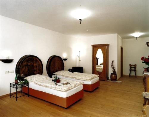 DorsheimGästehaus zum Goldberg的大房间设有两张床和镜子