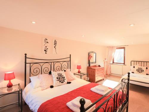 WigtonHorseshoe Cottage的一间卧室配有一张带红色毯子的大床