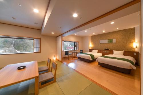 黑部市Kurobe Unazukionsen Yamanoha的酒店客房配有两张床和一张书桌