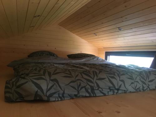 穆斯克龙Tiny House Otra Cosa的木天花板的客房内的一张床位