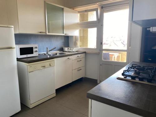 里斯本Olaias Signature Apartment的厨房配有水槽和炉灶 顶部烤箱