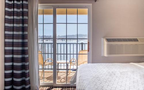 Le Claire勒克莱尔河滨 - 达文波特智选假日酒店的一间卧室设有一张床和一个美景阳台
