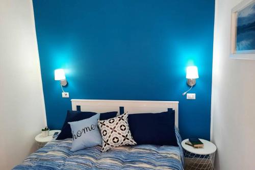 维博瓦伦蒂亚Meli's House的一间蓝色卧室,配有一张带两张桌子的床