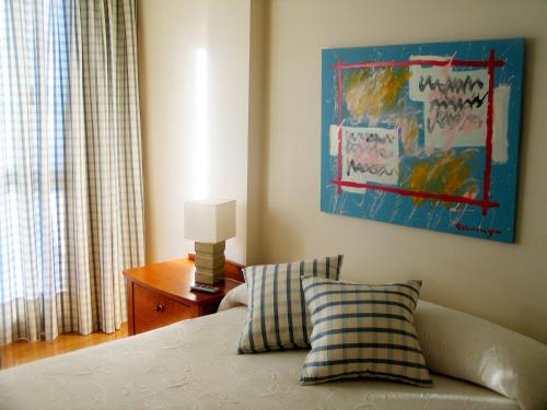 LuyandoURDINETXE的卧室配有一张床,墙上挂有绘画作品