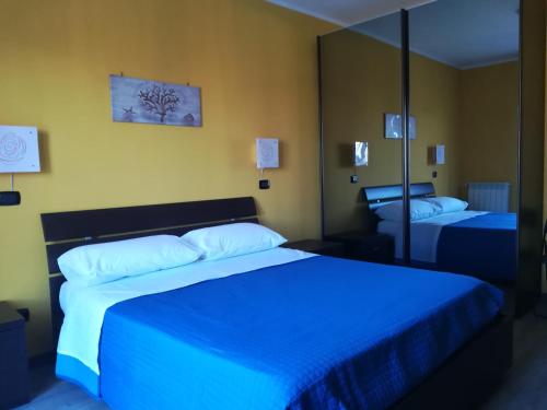罗马Romanina Appartamento Giuland的一间卧室配有两张带蓝色床单和镜子的床