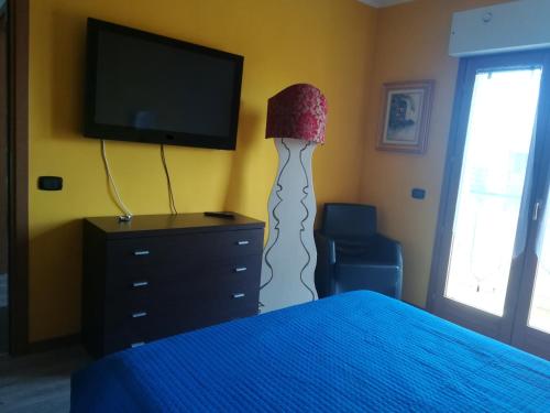 罗马Romanina Appartamento Giuland的一间卧室配有一张床、一盏灯和一台电视
