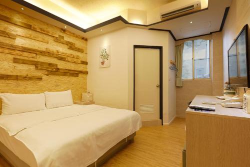 台南府城商旅文创新馆的卧室配有白色的床和书桌