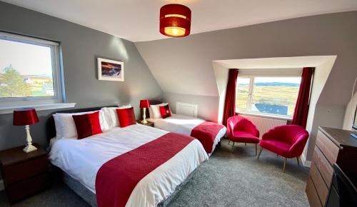 波特里Blacksmith holiday cottage near Portree in central Skye的一间卧室配有两张床和两张红色椅子