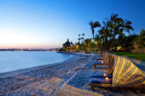 圣地亚哥巴伊亚度假酒店的黄昏时在海滩上长着一排长椅