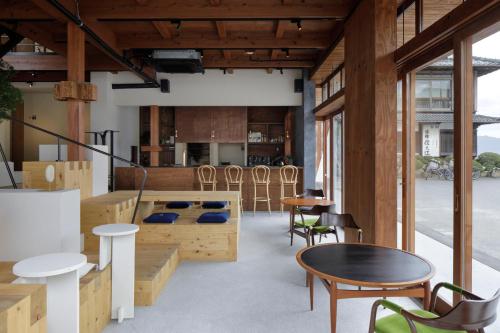 尾道市SOIL Setoda的配有木制家具和桌椅的房间