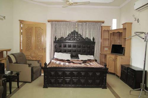 伊斯兰堡Butt Lodges 3的一间卧室,卧室内配有一张黑色大床