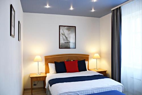帕兰加Žalias namas的一间卧室配有一张带两张台灯的床铺。