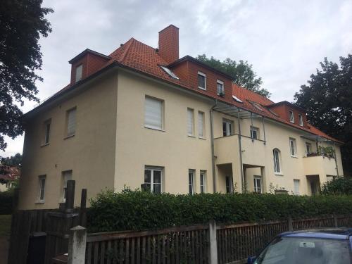 德累斯顿Ferienwohnung Tapetenwechsel -Balkon-的一座大型白色房屋,设有红色屋顶