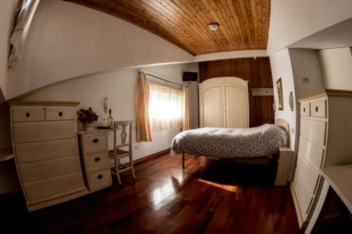 阿巴迪亚圣萨尔瓦托雷Albergo Generale Cantore - Monte Amiata的一间卧室配有一张床、一个梳妆台和一扇窗户。