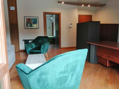 莱切B&B SALento Garden的客厅配有两张绿色椅子和书桌