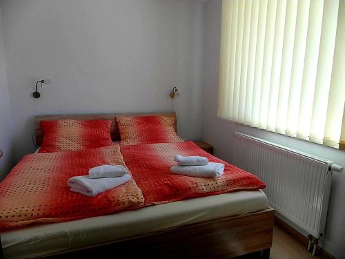 劳耶克特普利采Apartmány Dalila的一间卧室配有红色的床和毛巾