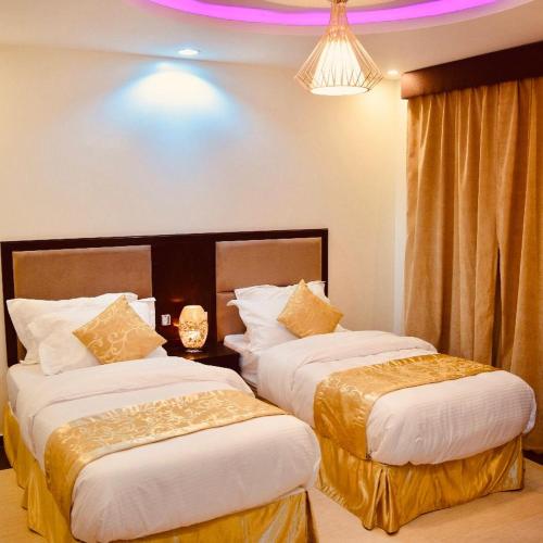 艾卜哈شاليهات رميس للعائلات RAMIS Chalet的酒店客房设有两张床和吊灯。