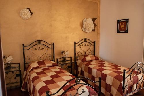 吉齐奥河畔佩托拉诺"Il Miglio" Country House的配有床单的客房内的两张床
