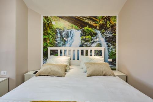 索科矿泉村AquaLux 2的一间卧室配有一张白色的床和瀑布壁画