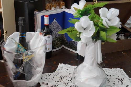 布林迪西monolocale "le sciabiche"的花瓶,桌子上装有鲜花和葡萄酒