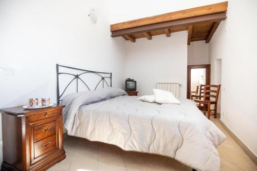 Isola del GiglioCasaMatta2的一间卧室配有一张大床和一个木制梳妆台
