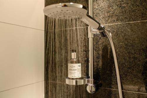 林茨Motel One Linz-Hauptplatz的浴室提供淋浴和1瓶肥皂