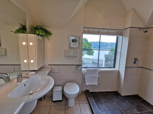 阿卡罗阿布鲁斯海滨公寓酒店的一间带水槽和卫生间的浴室以及窗户。