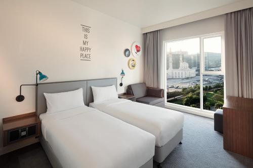 迪拜Rove City Centre, Deira的配有窗户的酒店客房内的两张床