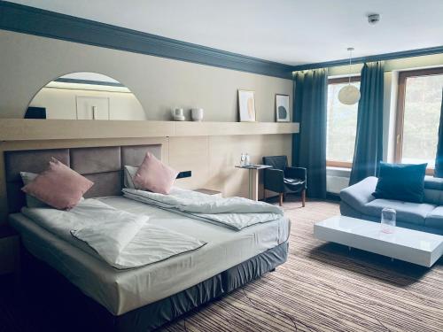 谢维日自然商务SPA酒店的一间卧室配有一张床、一把椅子和镜子