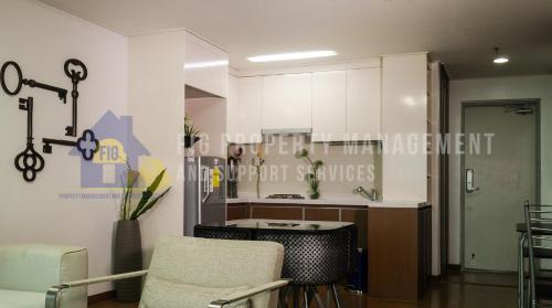 克拉克Donggwang Condo @ Clark Freeport Zone的一间厨房,里面配有白色的橱柜和椅子