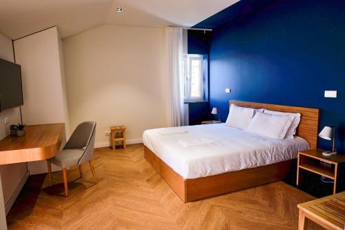 英雄港Mid-Atlantic Boutique Hostel的一间卧室设有一张蓝色墙壁的大床