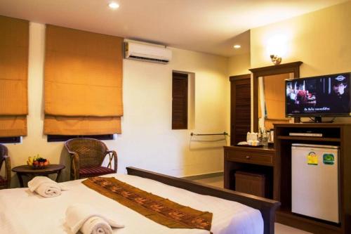 拉迈华泰楼酒店的配有一张床和一台平面电视的酒店客房