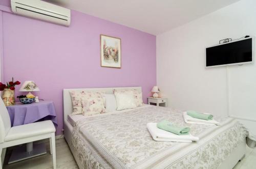 杜布罗夫尼克库克旅馆的一间卧室设有紫色墙壁和一张带毛巾的床