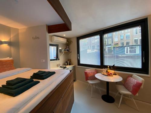 阿姆斯特丹Houseboat Sophia的一间卧室配有一张床和一张桌子及椅子