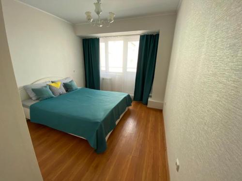 安加尔斯克Apartments 29 micro-district的一间卧室设有蓝色的床和窗户。