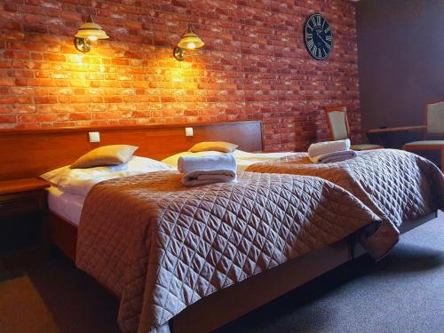 克拉普科维采塞克维梅恩酒店的一间卧室设有两张床和砖墙