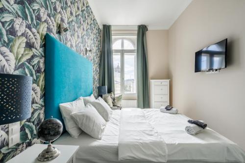 布达佩斯Nador Boutique- Best Location, By BQA的一间卧室配有一张白色大床和蓝色床头板
