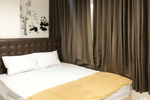 泗水SAS Guest House Mitra RedDoorz At Darmo Park 2 Surabaya的一间卧室配有一张带棕色床头板和窗帘的床