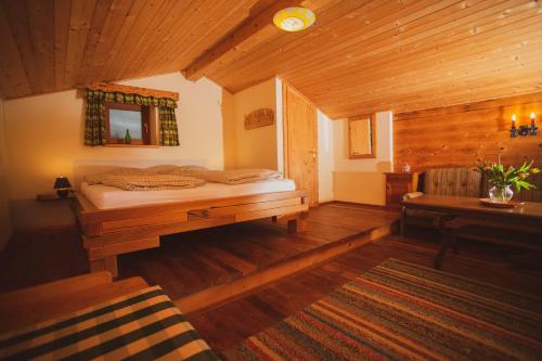 列兴Lesachtalerhof的小木屋内一间卧室,配有一张床