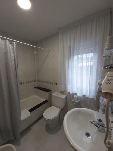 奥巴尔克伊洛Hostal O Forno的白色的浴室设有卫生间和水槽。
