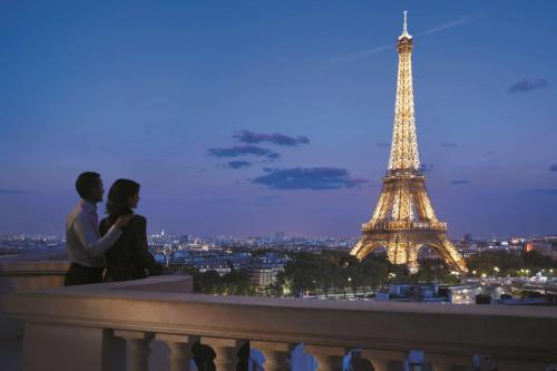 巴黎巴黎香格里拉的一对夫妇坐在埃菲尔铁塔前的一块地形上