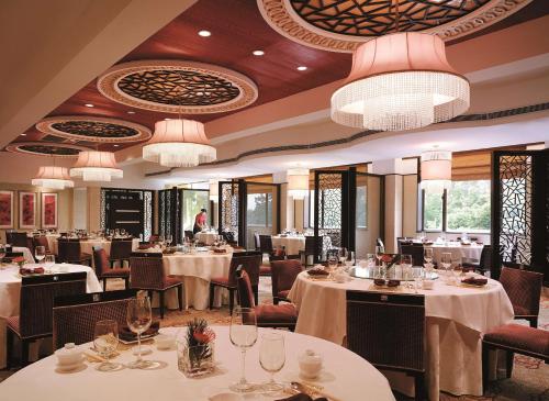 杭州杭州香格里拉的餐厅设有白色的桌椅和吊灯。