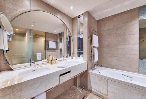 天津天津香格里拉的浴室设有2个水槽、浴缸和镜子