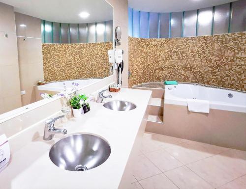 科尔多瓦Quorum Córdoba Hotel, Resort Urbano的浴室配有两个盥洗盆和浴缸。