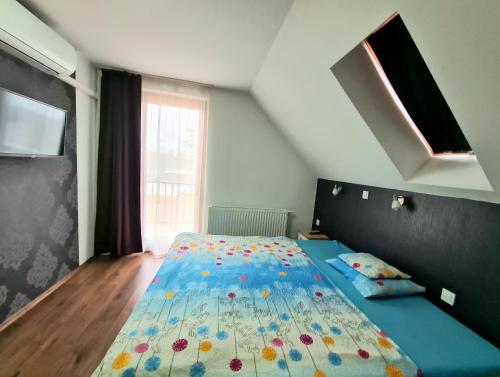 海吉克Székely-Lak Apartman Hegykő的一间卧室配有一张带蓝色棉被的床