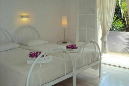康托卡利Maison Metel的一间白色卧室,配有两张床和窗户