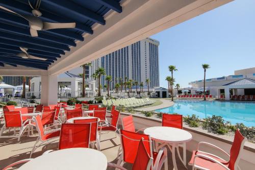 拉斯维加斯Westgate Las Vegas Resort and Casino的一个带桌椅的庭院和一个游泳池