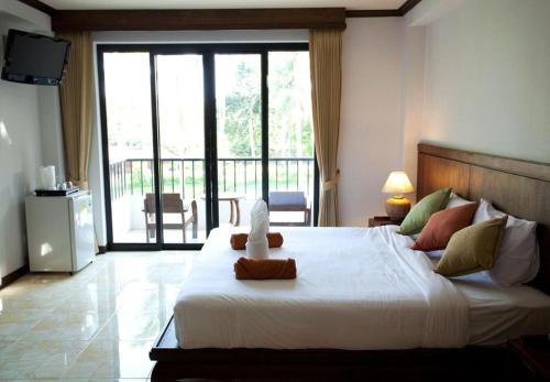 拉迈椰子海滩度假村的卧室设有一张大白色床和阳台