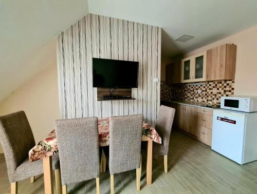 索普隆Székely Ház的厨房配有桌椅,墙上配有电视
